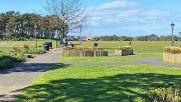 A park with pathways, flower beds, and benches.