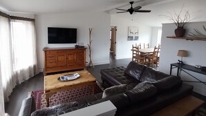 Una sala de estar moderna con un sofá, una mesa de centro, un mueble de madera y un televisor de pantalla plana.