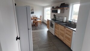 Una cocina moderna con armarios de madera, horno empotrado y un amplio ventanal que proporciona luz natural.