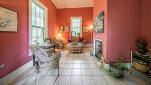 Un salon chaleureux, avec des meubles en osier, un ventilateur de plafond et une cheminée.