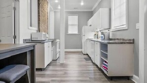 A modern kitchen with white cabinetry, a wooden countertop, and a built-in oven. - AV Bungalows #9A with Loft (Arcadia)