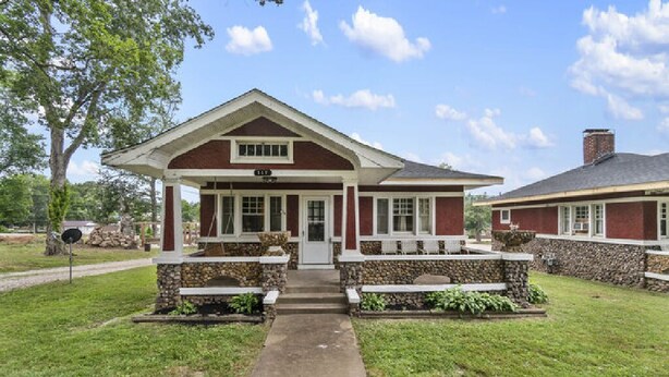 A two-story building with a covered porch and stone steps. - AV   Bungalows    #8 (Arcadia)