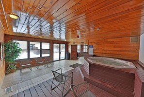 A wooden interior with a hot tub, seating area, and large windows. - Downtown Luxury + Hot Tubs + Walkable Winter Park (Winter Park)
