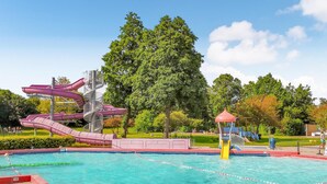 Ein Schwimmbad mit Wasserrutsche und Spielbereich.
