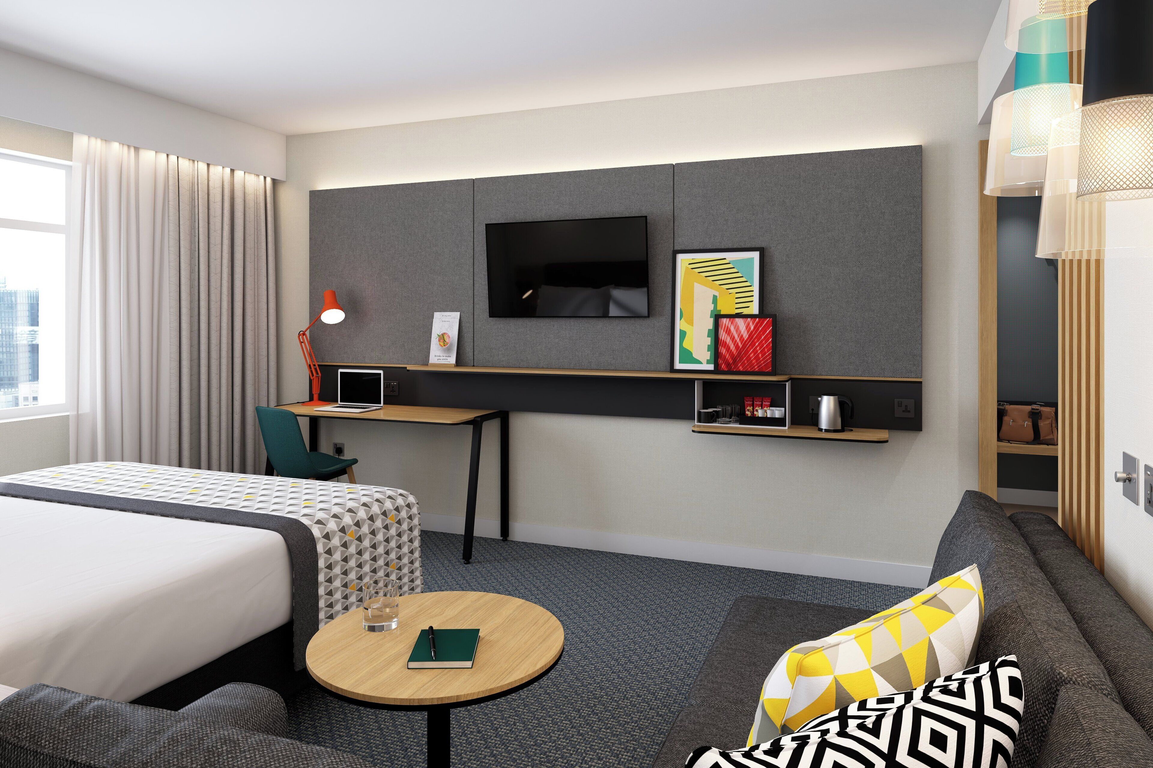 A modern hotel room with a bed, a desk, a TV, and a sofa.