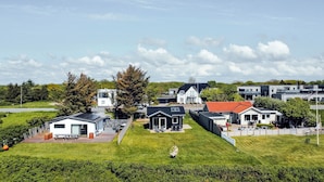 Un quartier résidentiel avec des maisons modernes, une pelouse verdoyante et un ciel dégagé.