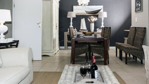 Un salon avec un canapé blanc, une table à manger avec des chaises et un tapis.