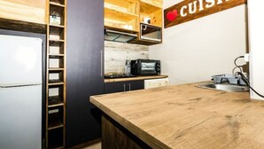 Une cuisine équipée d’un plan de travail en bois, d’un four à micro-ondes, d’un grille-pain et d’un réfrigérateur.