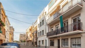 A street with multi-story residential buildings, balconies, and a parked car. - Apartament Sant Mateu (Vilassar de Mar)