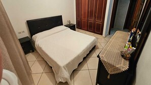 A bedroom with a bed, a nightstand, a dresser, and a wardrobe. - Appartement (Tangier)