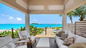 A beachside lounge with a wooden deck, white cushioned seating, and a view of the ocean. - CIESTA SANDS- Beachfront Luxury, Top Beach, 4 bedrooms w private bath, Pool (Moore Hill)