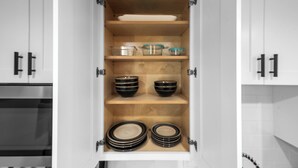 A kitchen cabinet with shelves containing bowls, plates, and glass containers. - Barrel Retreat in the Heart of Downtown Phoenix (Phoenix)