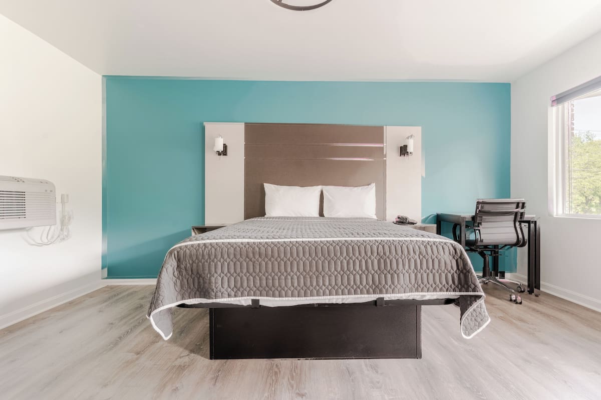 A modern bedroom with a bed, a desk, and a chair.