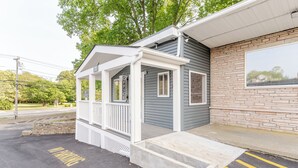 A small, single-story building with a porch and a brick exterior. - Blue Beach Motel (North Kingstown)