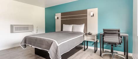 A modern bedroom with a bed, a desk, and a chair.