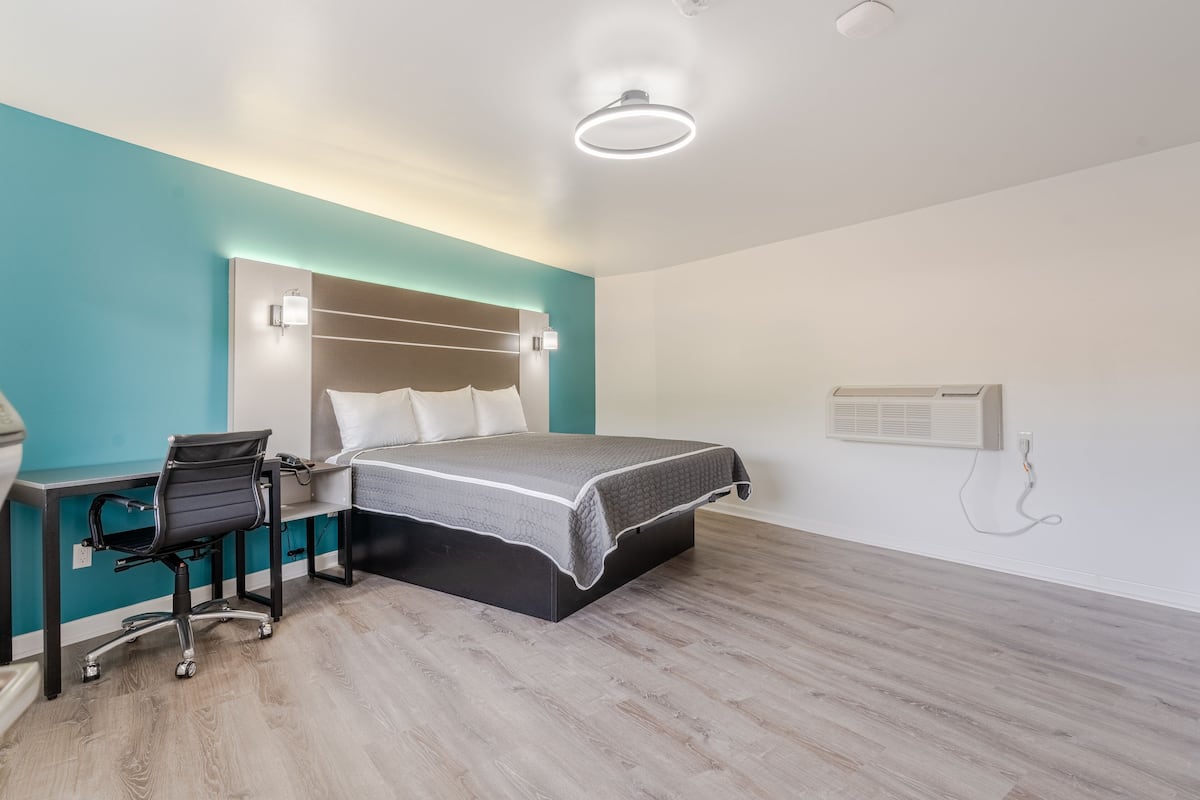 A modern bedroom with a bed, desk, and chair.