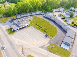 An aerial view of a motel with a parking lot, a small grassy area, and a building with a sign.