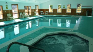 An indoor swimming pool with clear water, wooden walls, and multiple windows. - Trout Creek Unit 8, Beautiful newly Decorated Very Clean Condo , Building 2 (Harbor Springs)