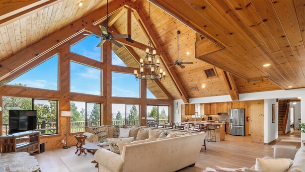 A spacious living area with a large sofa, a dining table, and a kitchen in the background.