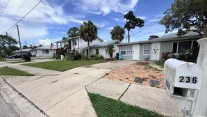 A residential street with houses, a mailbox, and a clear sky.