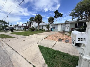 A residential street with houses, a mailbox, and a clear sky.