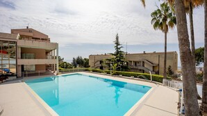 A swimming pool surrounded by buildings, with a clear sky above. - GuestHost - Amazing studio of 36 sqm, able to accommodate up to 3 people, located on the ground floor of a building in the quiet residential complex of Collina Fiorita. The property boasts a spacious terrace with fabulous views of Porto Sole and the avai (Sanremo)