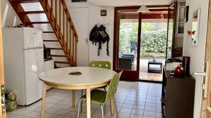 A compact kitchen with a dining area, a staircase, and a view of the outside. - 188 – House for 6 guests in the heart of the forest in Maubuisson (MAUBUISSON)