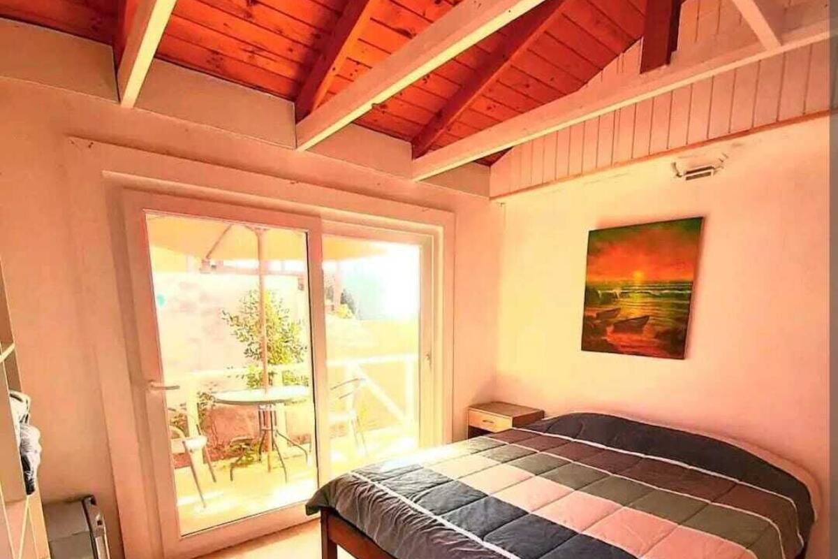 Ein Schlafzimmer mit einem großen Bett, einer Schiebetür zum Balkon und einem Gemälde an der Wand.