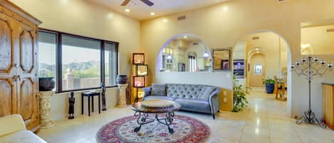 A spacious living room with a sofa, coffee table, and a large window.