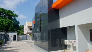 Un bâtiment moderne doté d’une façade réfléchissante et d’une touche de couleur orange.