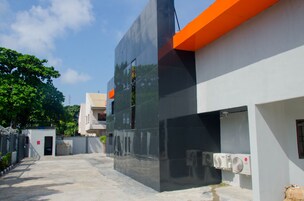 Un edificio moderno con fachada reflectante y detalles en color naranja.