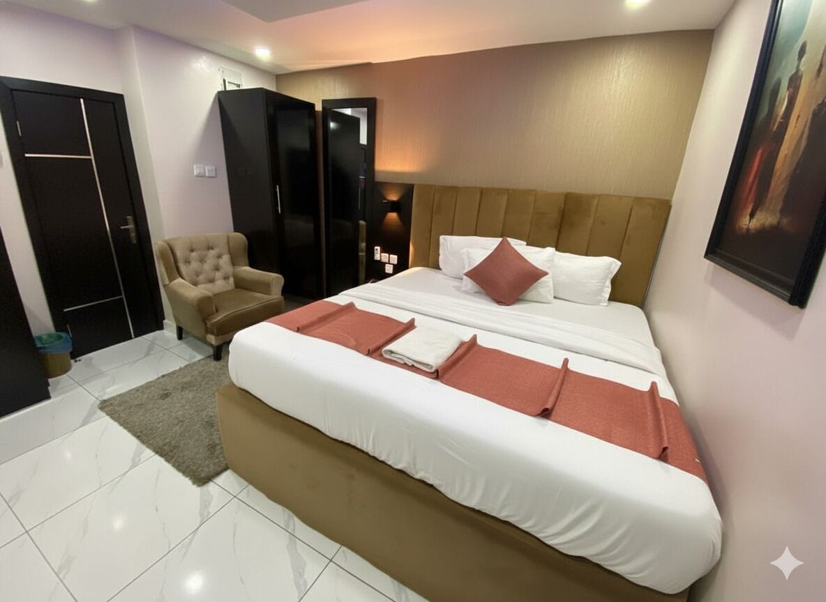 Habitación de hotel con una cama grande, una silla, un armario y un cuadro en la pared.