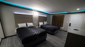 Una camera d'albergo con due letti, una scrivania e un armadio.