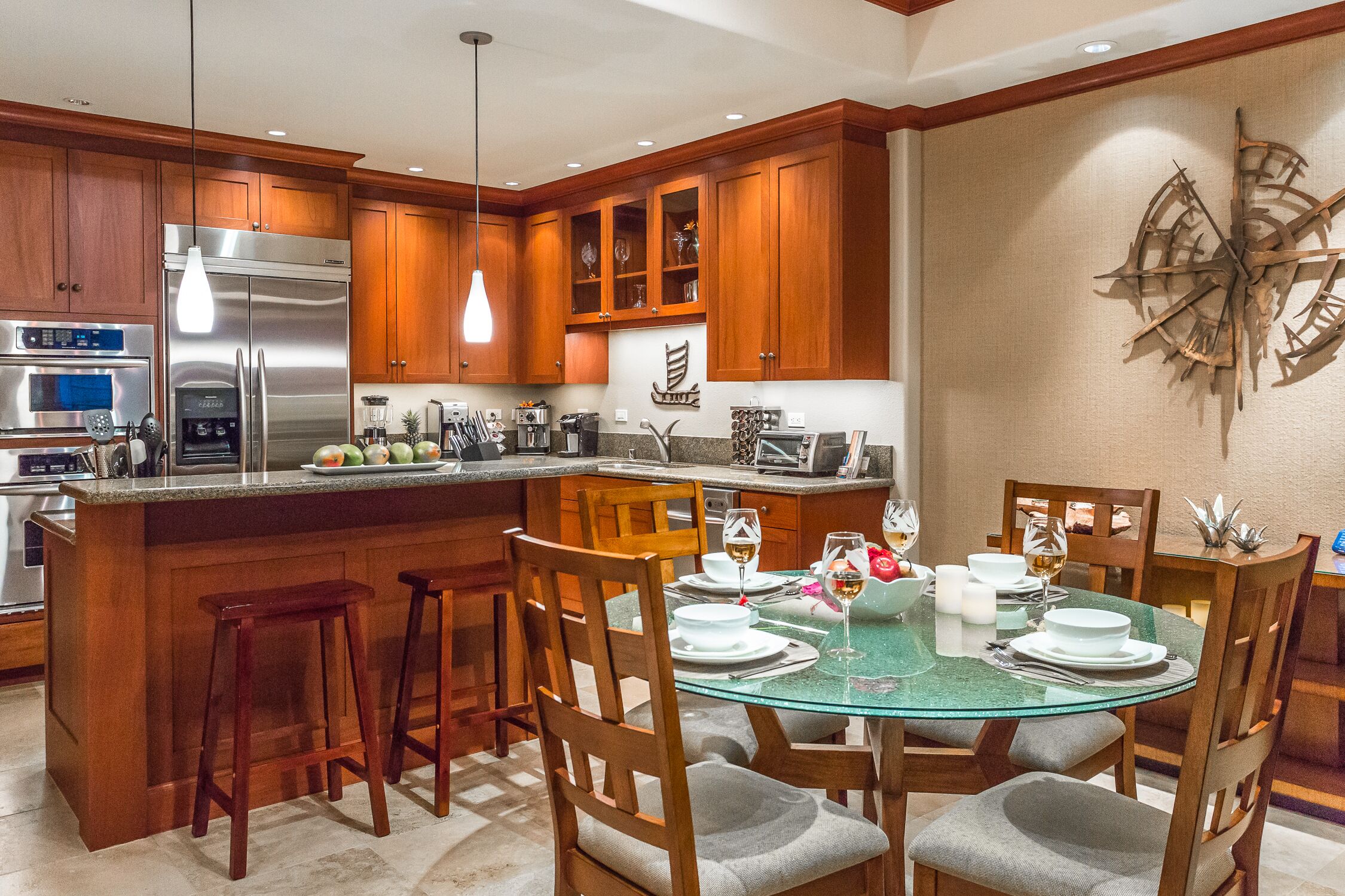 A modern kitchen with wooden cabinets, stainless steel appliances, and a glass dining table set for six.
