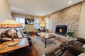 Een flatscreentelevisie, een open haard en tafelvoetbal