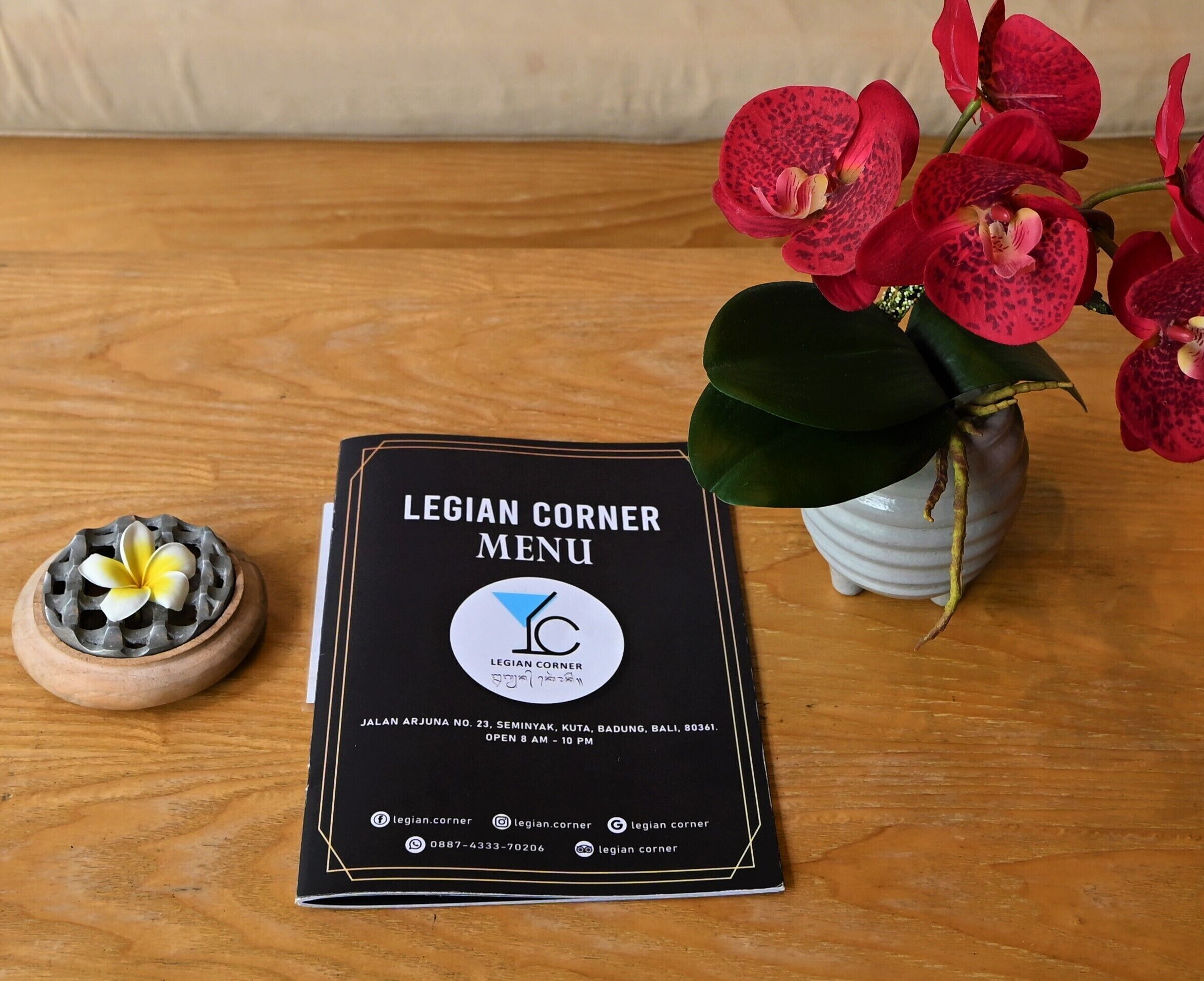 A menu titled "LEGIAN CORNER MENU" with contact information and social media icons.