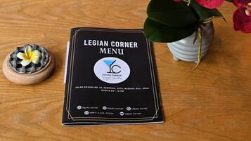 A menu titled "LEGIAN CORNER MENU" with contact information and social media icons.
