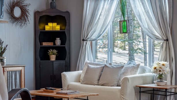 A cozy living room with a sofa, a coffee table, and a cabinet. - The Bigfork Riverside Retreat - No Cleaning Fee! (Bigfork)