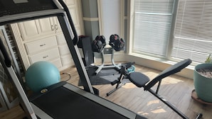 A home gym with a treadmill, exercise balls, and weights. - Estate Home Hot Tub Beach view Wi-Fi 8 acres 5000 sqft 4 bd 3.5 bath (Greenwood)