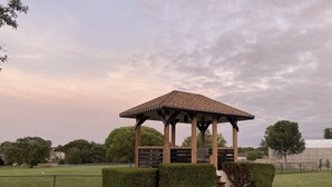 A gazebo with a tiled roof and wooden beams, surrounded by neatly trimmed hedges and grass. - Estate Home Hot Tub Beach view Wi-Fi 8 acres 5000 sqft 4 bd 3.5 bath (Greenwood)