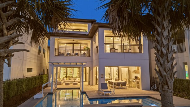 A modern two-story house with a pool, outdoor seating, and a balcony. - 9BR Reunion Mansion | Pool, Spa & Home Theater (Kissimmee)