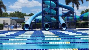 Un parc aquatique doté d’une grande structure de toboggans aquatiques et d’une piscine avec plusieurs couloirs de nage.