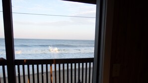 A wooden deck with a railing overlooking the ocean. - Cape Hatteras Motel (Buxton)