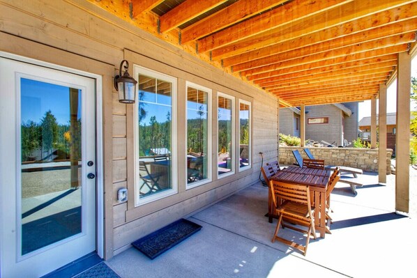 Enjoy a tranquil outdoor space with a wooden table, chairs, and stone bench, surrounded by breathtaking views.