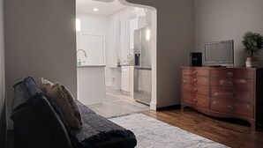 A living room with a sofa, a wooden cabinet, and a television.