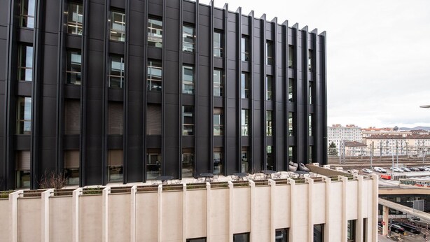 Un bâtiment moderne doté d’un toit plat et d’une série de fenêtres verticales.