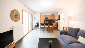 Un appartement moderne comprenant un salon, un coin repas et une cuisine.