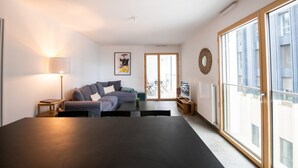 Un salon moderne avec un canapé d’angle, une table basse et un coin repas.