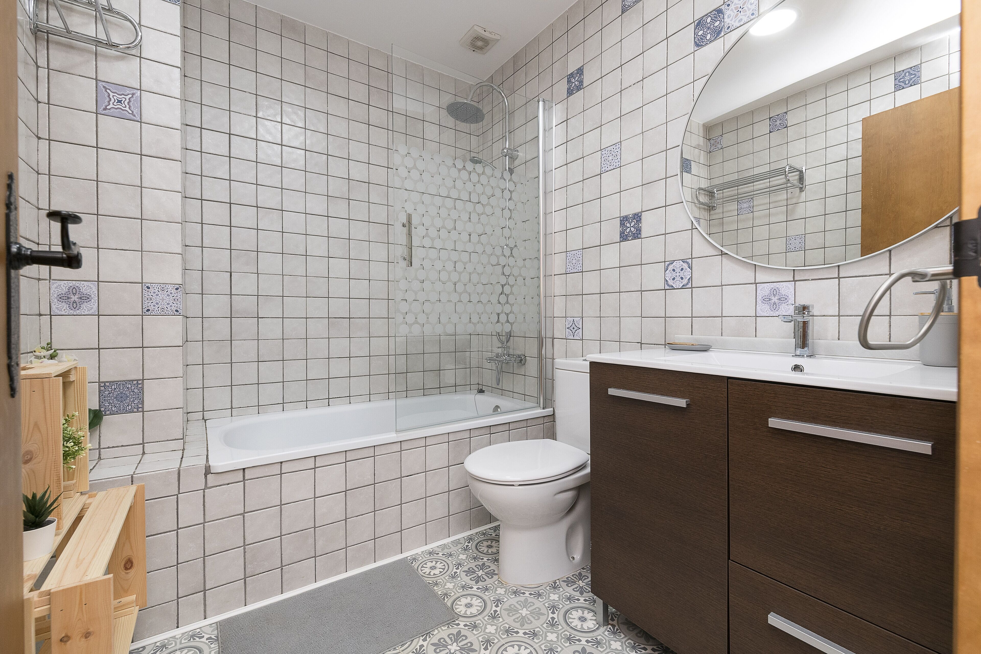 A bathroom with a bathtub, toilet, and wooden cabinets.