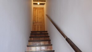A wooden staircase with a handrail leading to a wooden door at the top. - Charming town house in the center of Roses, Costa Brava! Two rooms, 200 meters from the beach. Modern kitchen and balcony with sea views. (Roses)